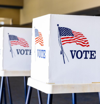 Two polling booths with an American flag and "VOTE" on the sides