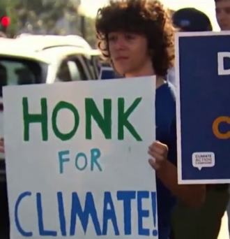 Protestor holds sign that reads "Honk for Climate!"