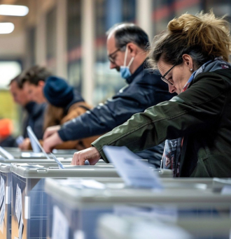 five people inserting their ballots into a ballot counting machine